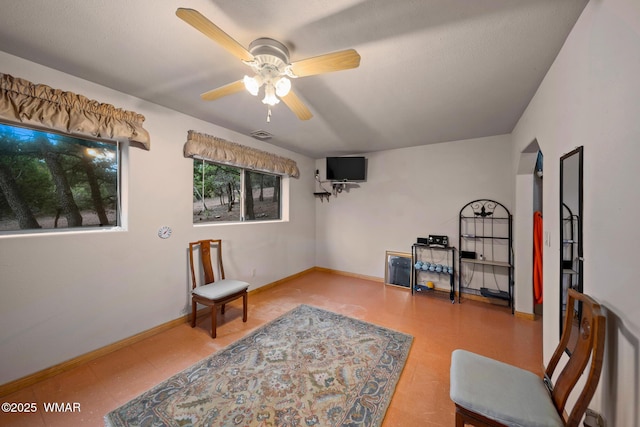 living area with tile patterned floors, baseboards, and a ceiling fan
