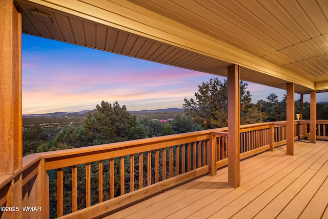 deck at dusk featuring a mountain view
