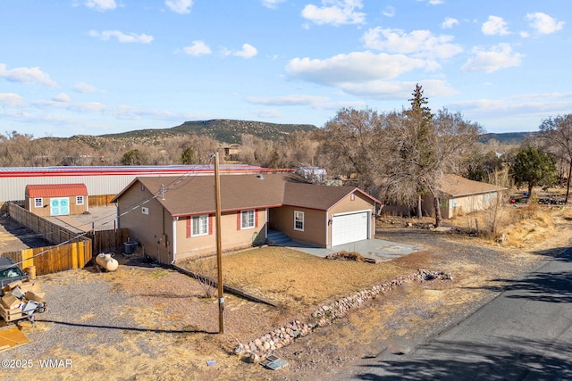 view of front of property featuring driveway, fence, and a mountain view