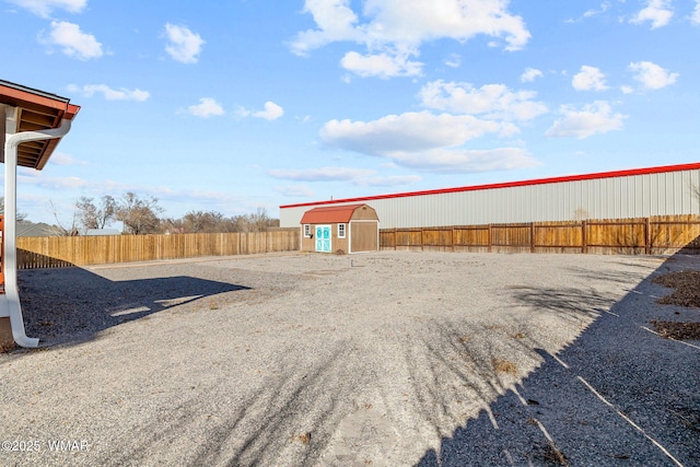 view of yard featuring an outbuilding, a storage unit, and a fenced backyard