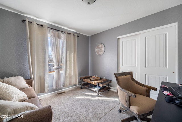 office space featuring a textured wall, carpet, and visible vents