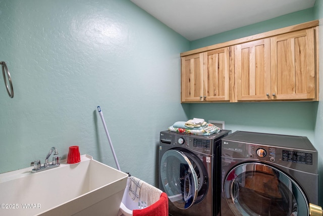 laundry room featuring cabinet space, washer and clothes dryer, and a sink