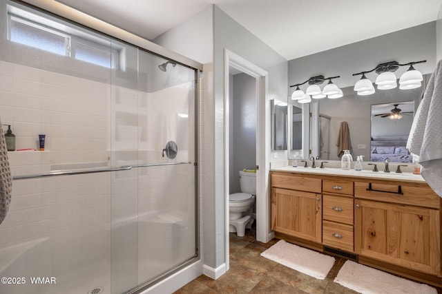 full bathroom featuring double vanity, a stall shower, a sink, and toilet