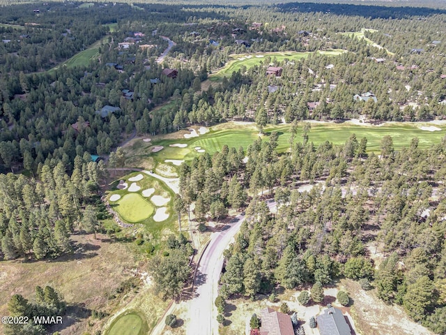 bird's eye view featuring view of golf course and a view of trees