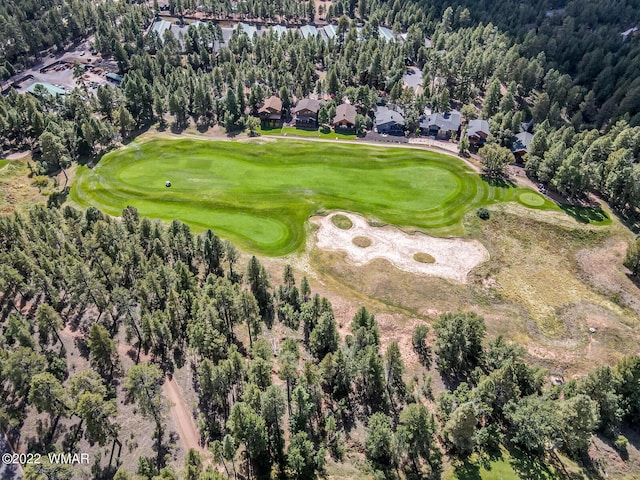 drone / aerial view with view of golf course and a view of trees