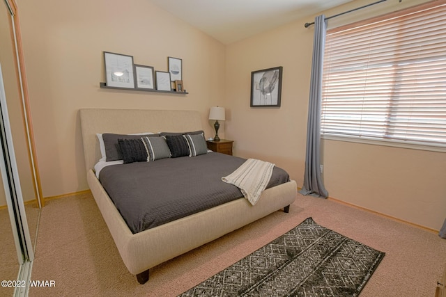 bedroom with carpet floors, vaulted ceiling, and baseboards