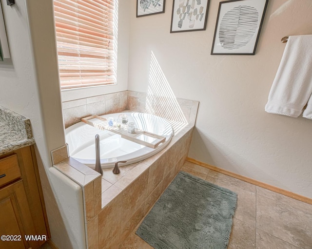 bathroom with tile patterned floors, a bath, and vanity