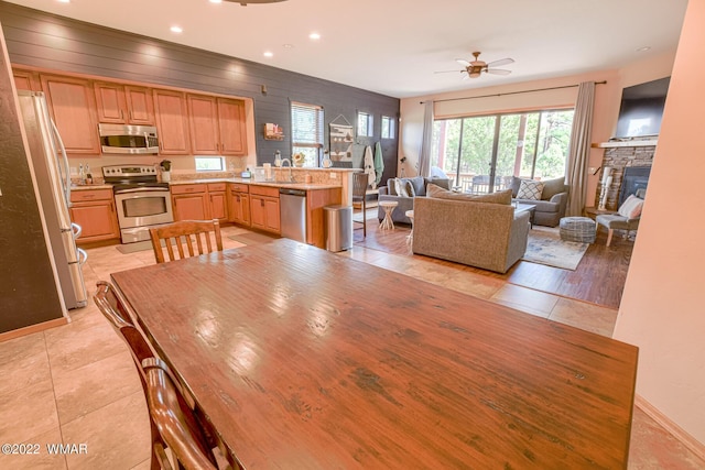 dining area featuring recessed lighting, ceiling fan, a stone fireplace, and light tile patterned floors