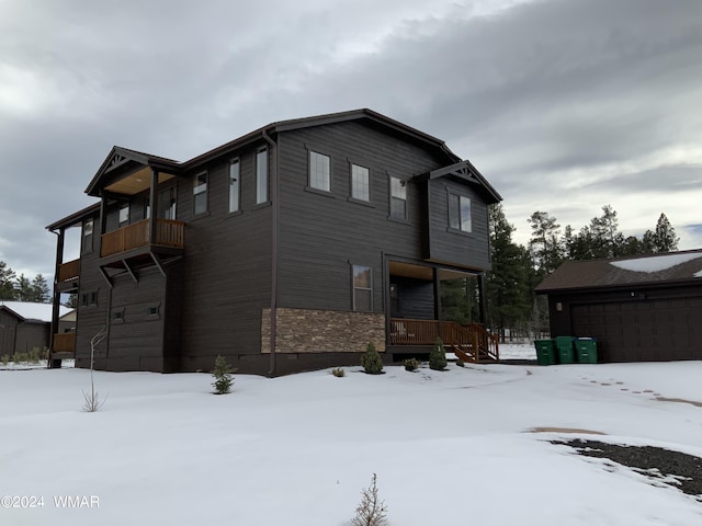 view of snow covered exterior with a garage and crawl space