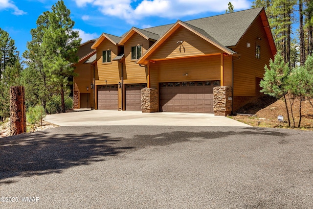 2320 Chandelle Ln, Overgaard, AZ 85933 - view of front of house with stone siding, concrete driveway, and an attached garage
