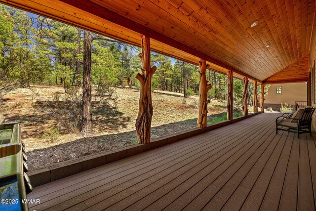2320 Chandelle Ln, Overgaard, AZ 85933 - unfurnished sunroom featuring vaulted ceiling and view of wooded area