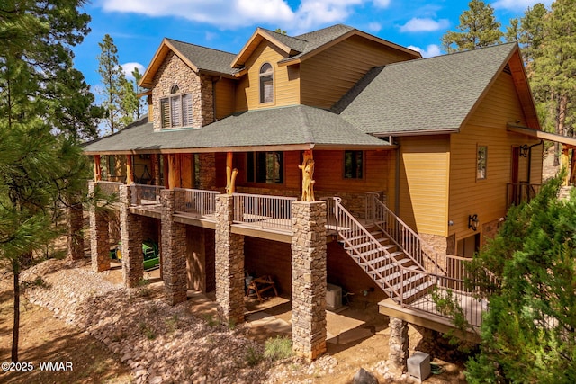 2320 Chandelle Ln, Overgaard, AZ 85933 - rear view of property featuring stone siding, a shingled roof, stairs, and a patio