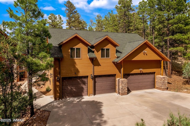 2320 Chandelle Ln, Overgaard, AZ 85933 - chalet / cabin with driveway, roof with shingles, an attached garage, and stone siding