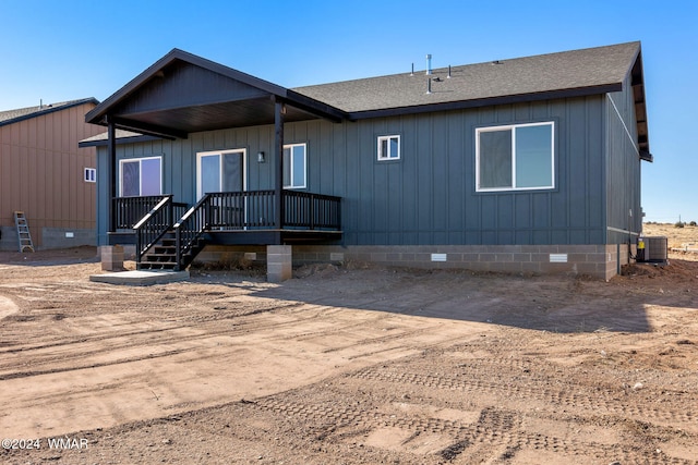 rear view of property featuring a shingled roof, crawl space, and central AC