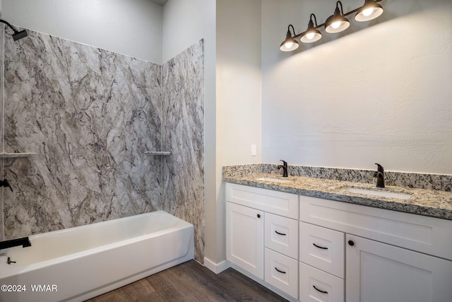 full bath with double vanity, wood finished floors, and a sink