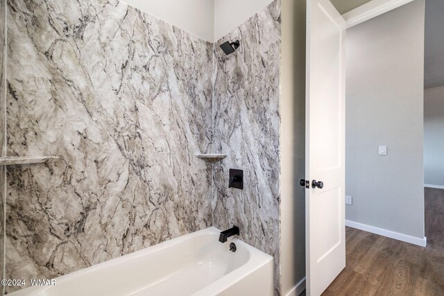 full bathroom featuring baseboards, wood finished floors, and shower / bathing tub combination