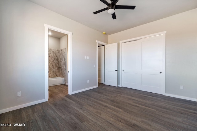 unfurnished bedroom with a ceiling fan, baseboards, a closet, dark wood-style floors, and ensuite bath