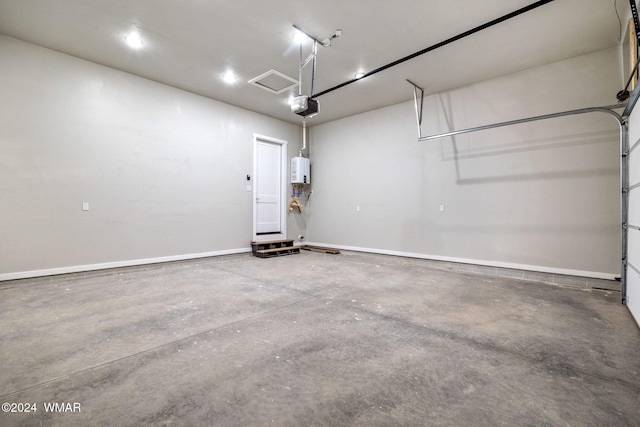 garage with a garage door opener, tankless water heater, visible vents, and baseboards