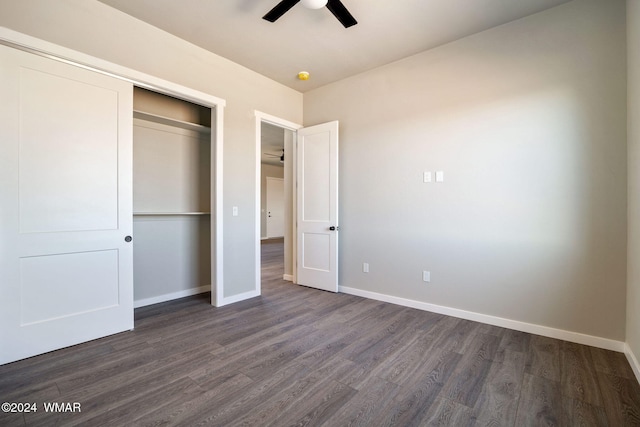 unfurnished bedroom featuring a closet, dark wood finished floors, and baseboards