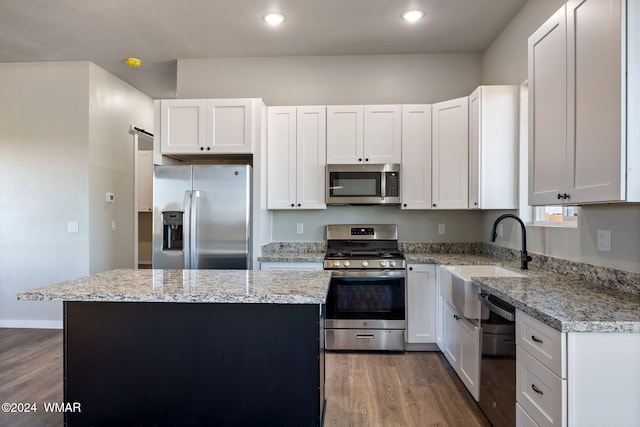 kitchen featuring appliances with stainless steel finishes, white cabinetry, and a center island