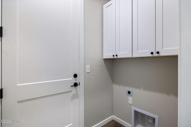 washroom featuring baseboards, cabinet space, and hookup for an electric dryer