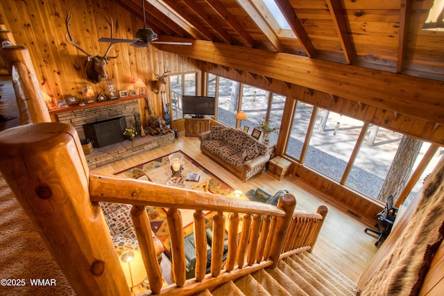 living area with wood walls, wood finished floors, lofted ceiling with skylight, and wood ceiling