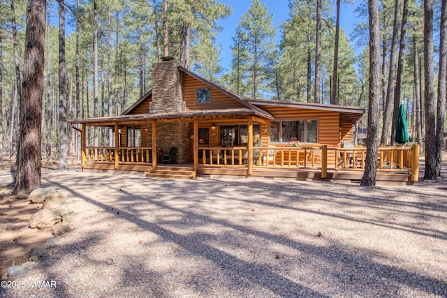view of front of property featuring a chimney and log veneer siding