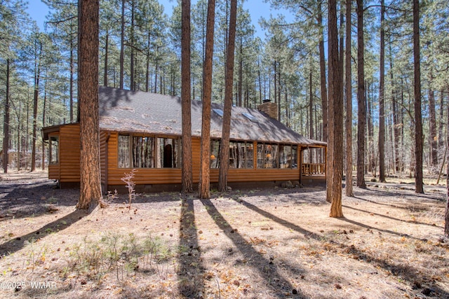 rear view of house with roof with shingles, a chimney, crawl space, and log veneer siding