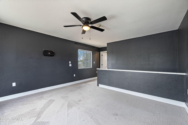 empty room featuring baseboards, ceiling fan, and carpet flooring