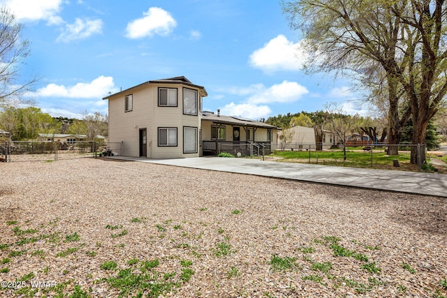back of property with a fenced backyard and a patio area
