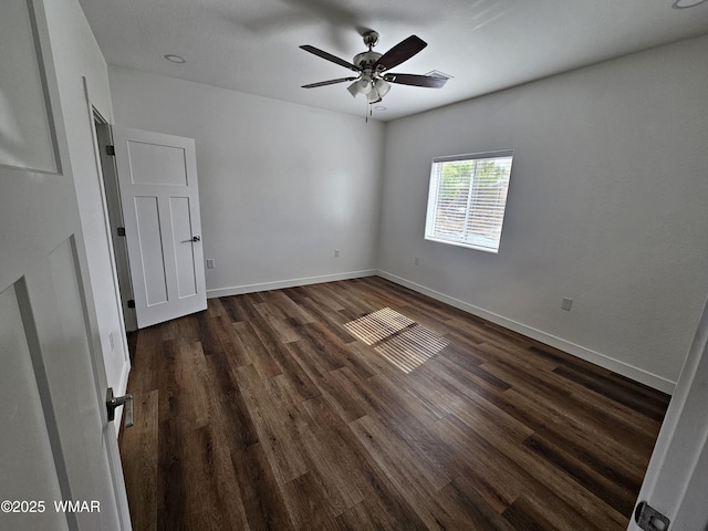empty room with baseboards, dark wood-style flooring, ceiling fan, and visible vents