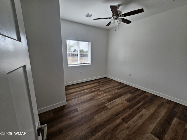 spare room featuring baseboards, a ceiling fan, dark wood-style flooring, and visible vents