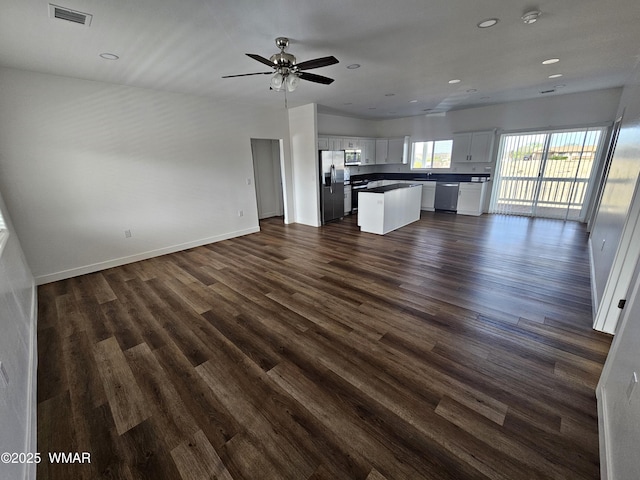 unfurnished living room with dark wood-style flooring, recessed lighting, baseboards, a ceiling fan, and visible vents