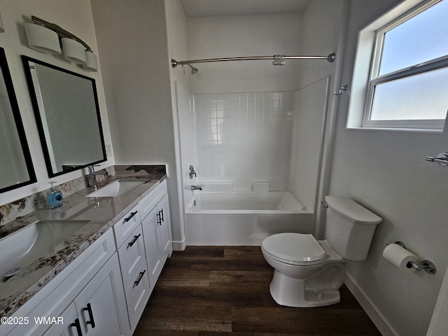 full bathroom with double vanity, wood finished floors, toilet, shower / tub combination, and a sink