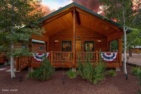 exterior space with a porch and log exterior