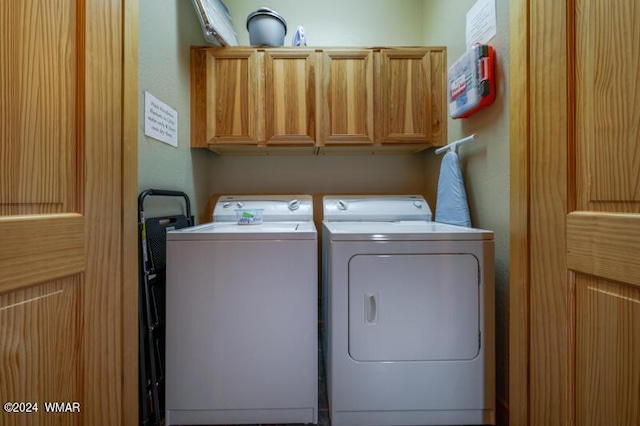 clothes washing area with cabinet space and washing machine and dryer