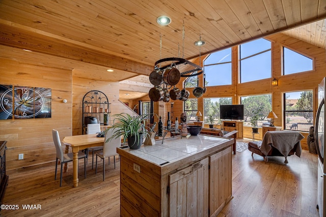 2796 Chandelle Ln, Overgaard, AZ 85933 - kitchen featuring tile counters, wood ceiling, wood walls, light wood-type flooring, and open floor plan