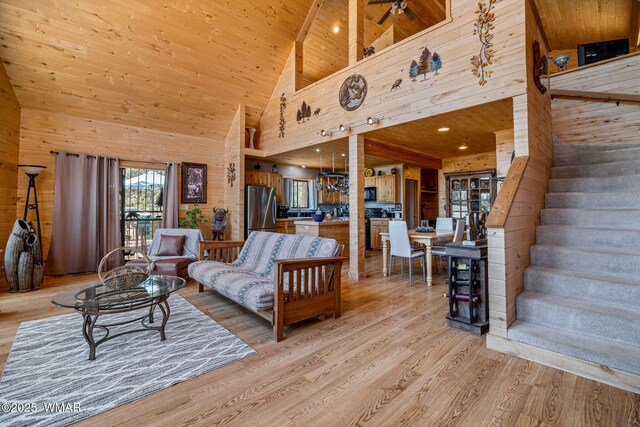 2796 Chandelle Ln, Overgaard, AZ 85933 - living area featuring wood walls, light wood-style flooring, high vaulted ceiling, wood ceiling, and stairway