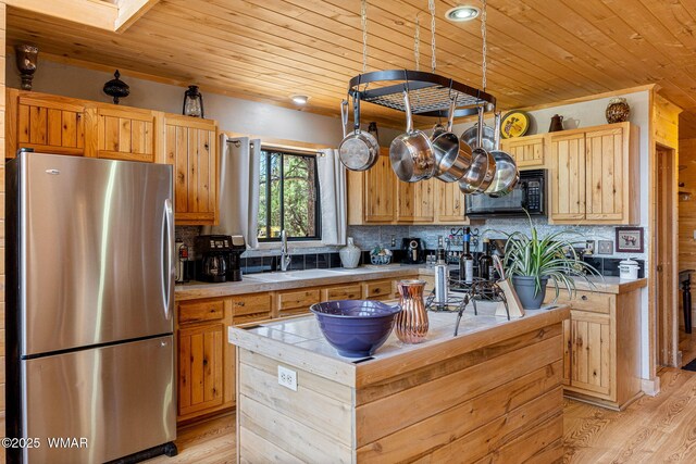 2796 Chandelle Ln, Overgaard, AZ 85933 - kitchen with freestanding refrigerator, wood ceiling, black microwave, light wood-type flooring, and decorative backsplash
