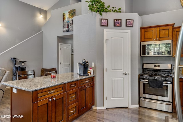 20 N Fox, Show Low, AZ 85901 - kitchen with stainless steel appliances, lofted ceiling, wood finished floors, a peninsula, and light stone countertops