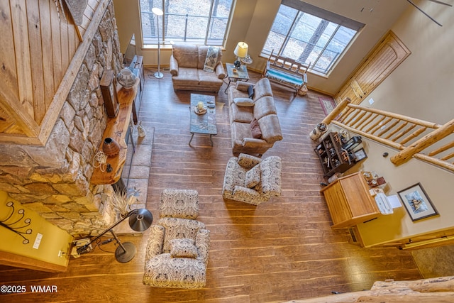 unfurnished living room featuring stairs, wood finished floors, and baseboards