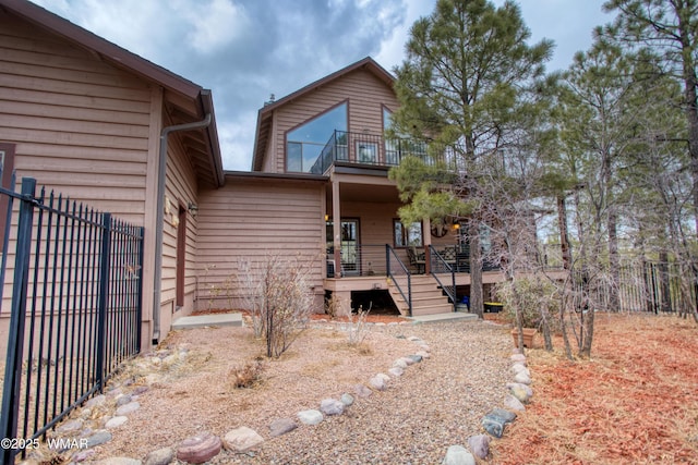 exterior space featuring covered porch, fence, and a balcony