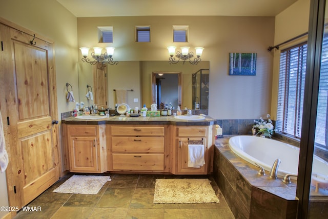 full bathroom with double vanity, a sink, a bath, and an inviting chandelier