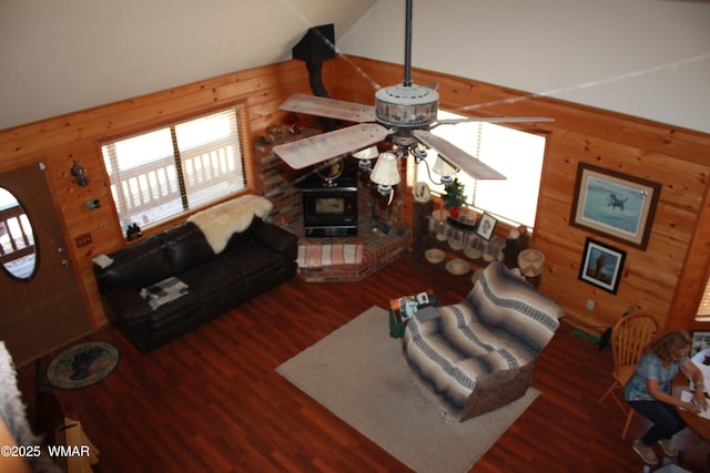 1890 Coyote Pl, Show Low, AZ 85901 - living room featuring wooden walls, a wood stove, wood finished floors, a ceiling fan, and vaulted ceiling