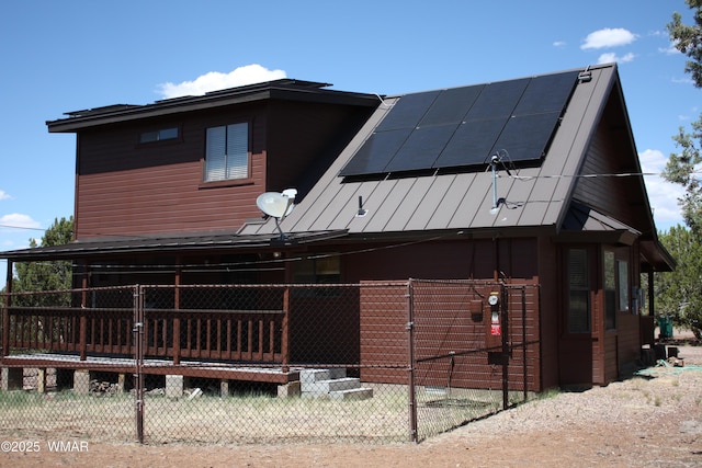 1890 Coyote Pl, Show Low, AZ 85901 - back of house featuring a standing seam roof, roof mounted solar panels, and a metal roof