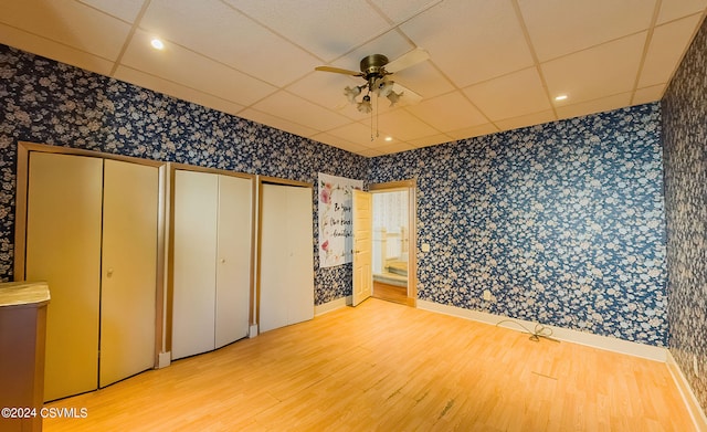 unfurnished bedroom with connected bathroom, two closets, ceiling fan, and light hardwood / wood-style flooring