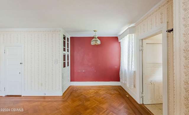 unfurnished dining area featuring ornamental molding and parquet flooring