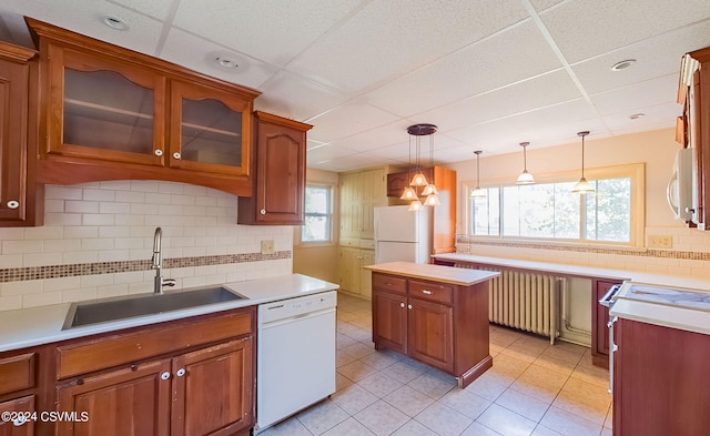 kitchen featuring white appliances, a drop ceiling, radiator heating unit, and sink