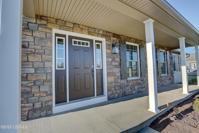 property entrance featuring stone siding and covered porch