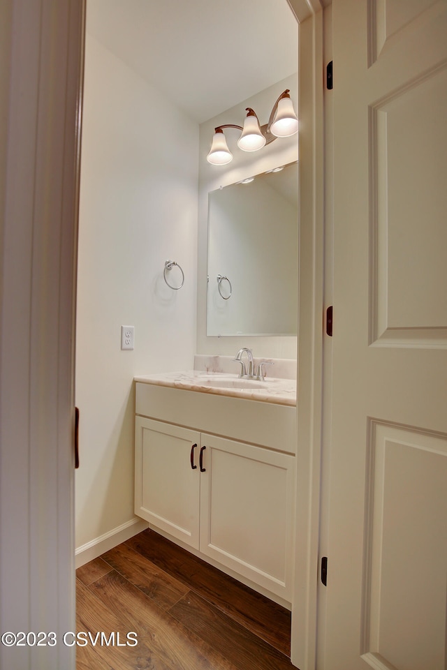 bathroom featuring vanity, baseboards, and wood finished floors